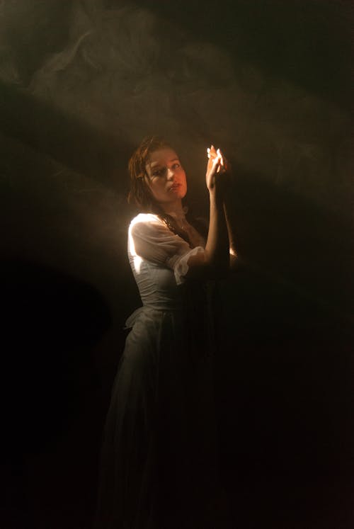 Free Woman in White Dress Posing in Darkness Stock Photo