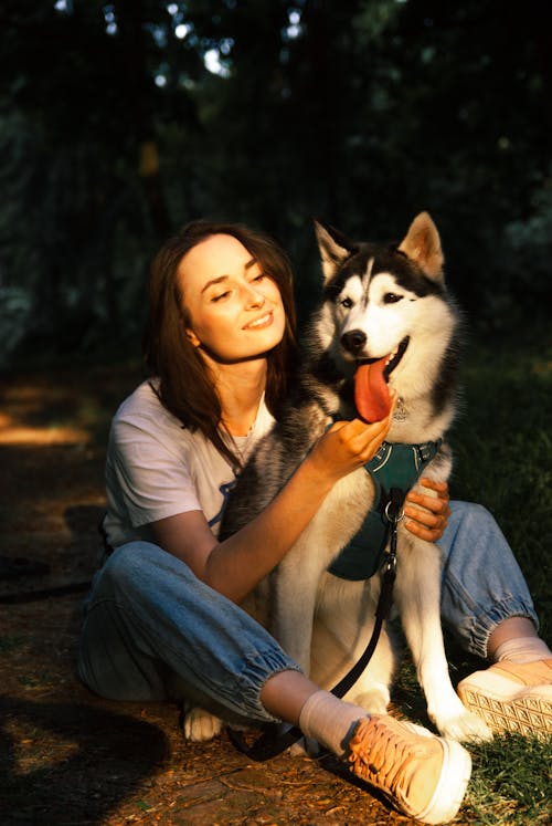 Woman Sitting and Hugging Husky Dog