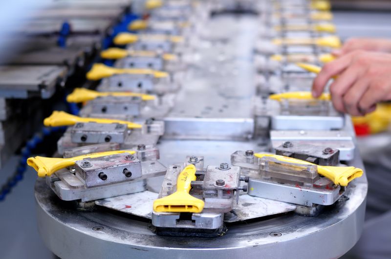 Close-up of a factory production line with yellow components being assembled