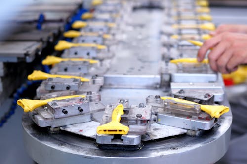 Free Close-up of a factory production line with yellow components being assembled. Stock Photo Free Close-up of a factory production line with yellow components being assembled. Stock Photo