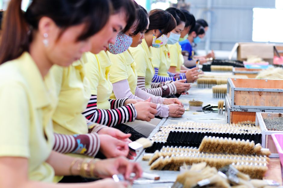 Women in a factory focusing on manufacturing with teamwork and precision.