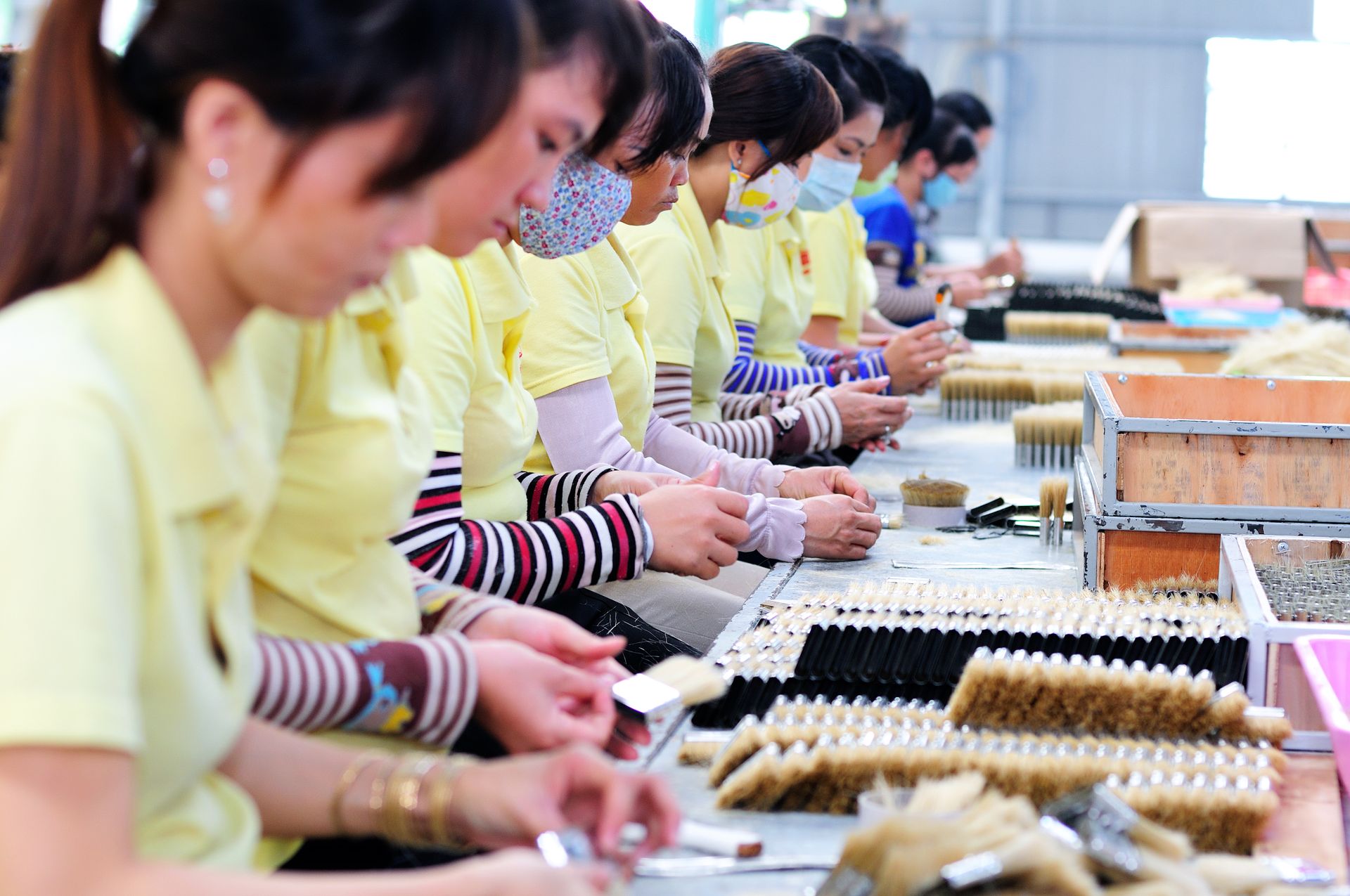 Women in a factory focusing on manufacturing with teamwork and precision.