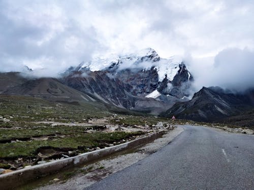 asfalt, karlı dağ, kılavuzluk içeren Ücretsiz stok fotoğraf