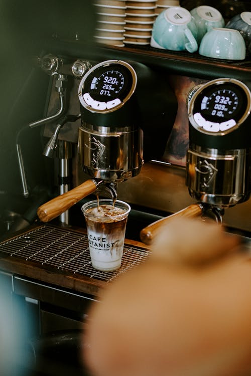 View of an Espresso Machine and a Cup of Iced Coffee in a Cafe