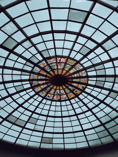 Free A breathtaking view of a circular glass ceiling with a colorful stained glass centerpiece. Stock Photo