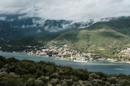 Free Breathtaking aerial view of Klinci village in Herceg Novi, Montenegro, surrounded by lush mountains and blue waters. Stock Photo