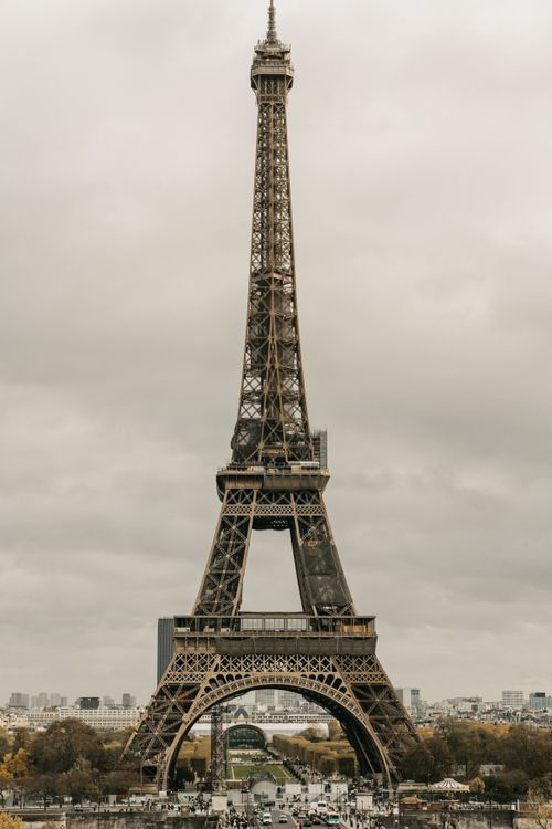 Free Iconic Eiffel Tower captured in a cloudy Paris skyline, showcasing its architectural majesty. Stock Photo