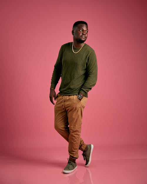 Young Man Posing in Olive Sweatshirt and Light Brown Pants