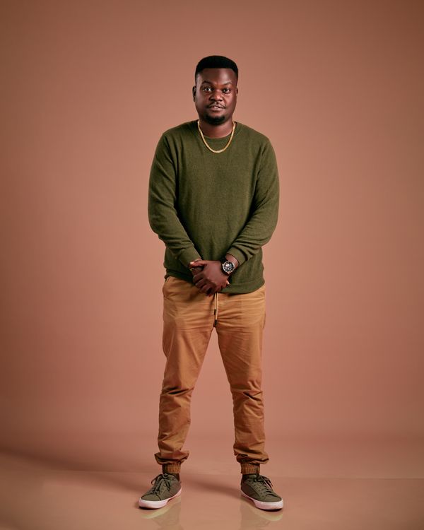 Young man in a green knit sweater and beige trousers