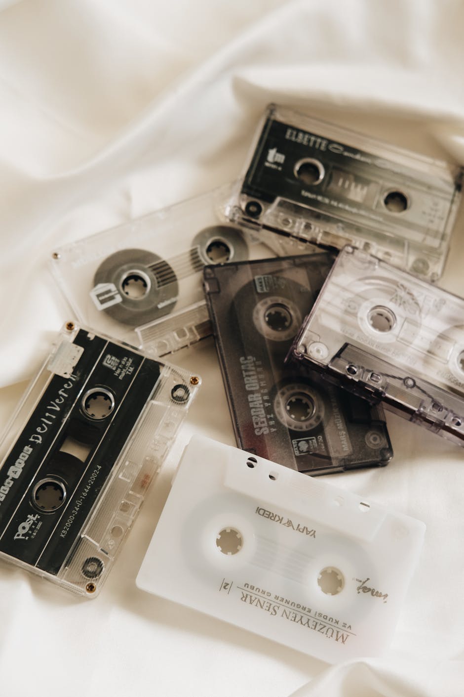 A collection of retro cassette tapes on white fabric evokes classic nostalgia.