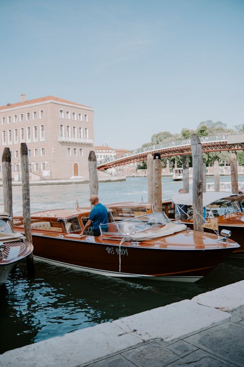 Man Standing in Water Taxi Boat Moored in Venice Harbor