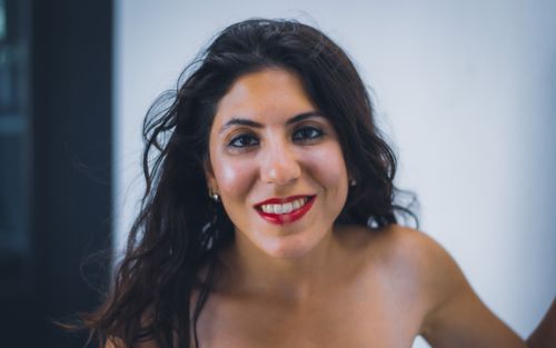 Free A cheerful woman with red lips smiles indoors, exuding joy and confidence. Stock Photo
