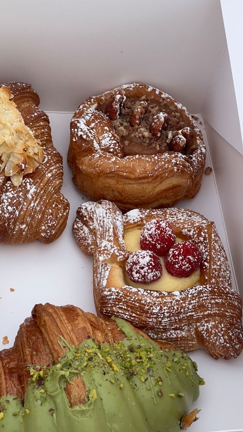 Free Delicious assortment of gourmet pastries featuring raspberry, pecan, and pistachio toppings. Stock Photo