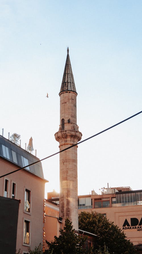 View of a Minaret between Buildings in City under Blue Sky 