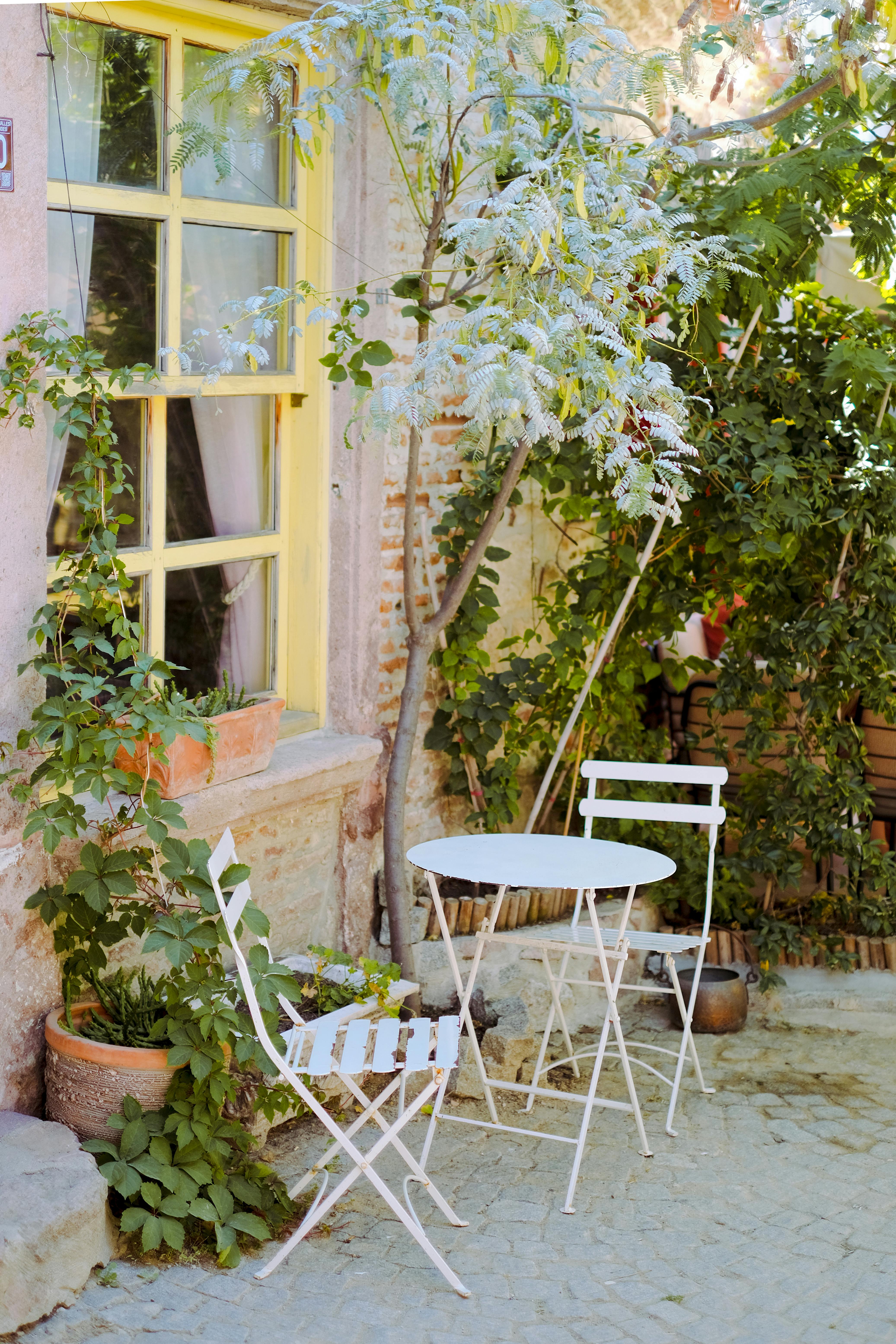 Serene patio setup with chairs, table, and abundant greenery in Küçükköy, Türkiye.