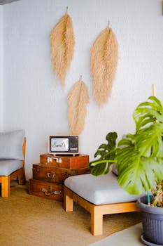 Warm and inviting living room with vintage suitcases, pampas grass decor, and a potted monstera.
