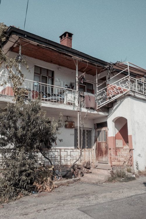 Free Lovely urban house with balconies and sunlit walls capturing a serene setting. Stock Photo