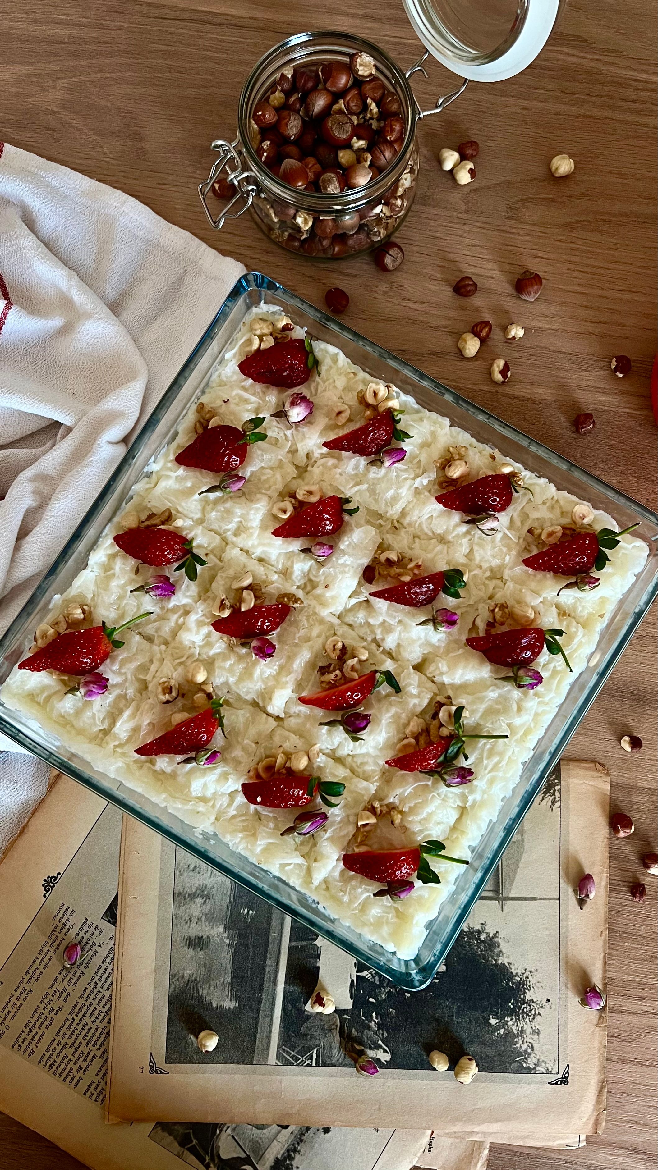 Square dessert with strawberries and nuts in glass dish, ideal for food photography.