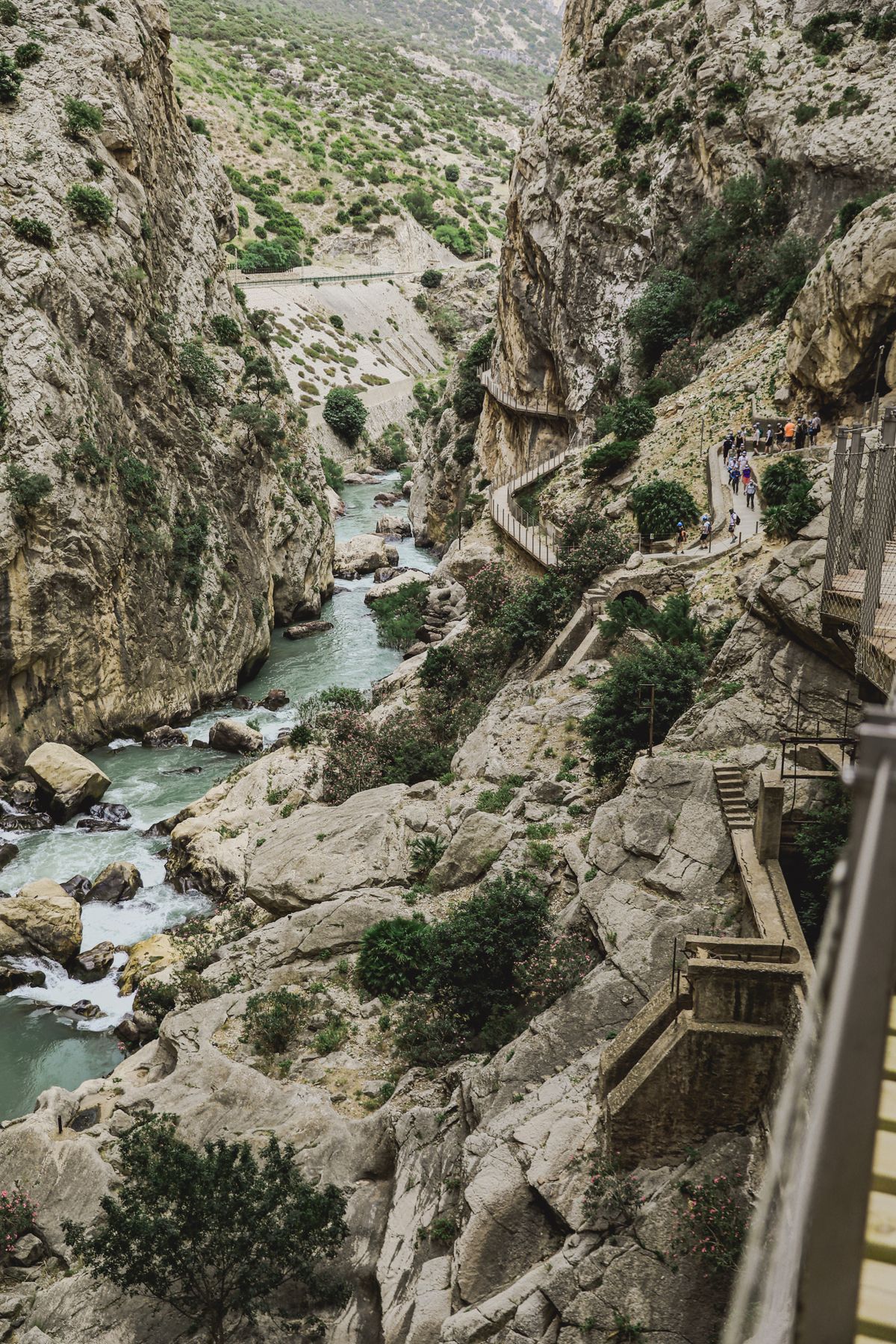 Walkers on a narrow section of the Caminito del Rey path in Malaga