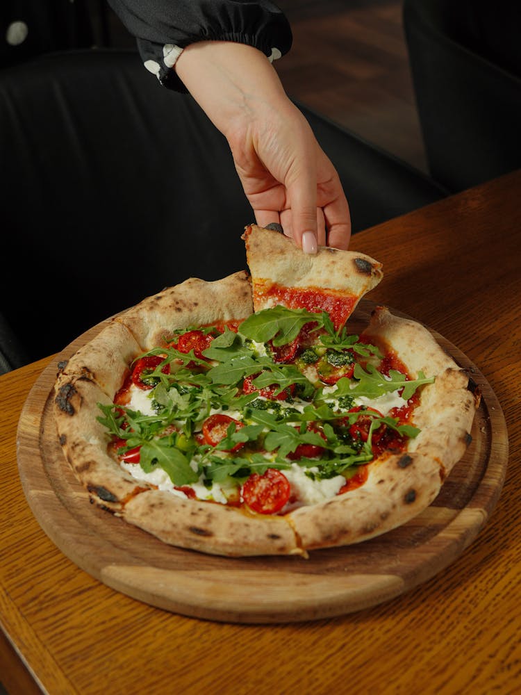 Woman Taking A Slice Of Pizza