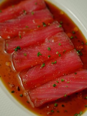 Prato com fatias de atum servido com vegetais e ervas frescas