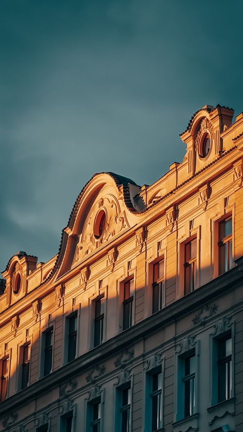 Free Elegant historic building facade with ornate architecture basked in warm sunlight. Stock Photo