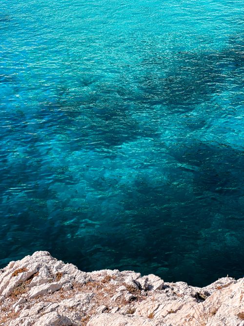 Free A breathtaking view of turquoise sea waters with natural rock formations along the seashore. Stock Photo