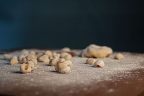 Free Close-up of freshly made pasta shells on a floured surface, perfect for food photography. Stock Photo