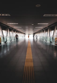 Photo by Luis González A walkway in a modern airport terminal showcasing sleek architecture and people walking.
