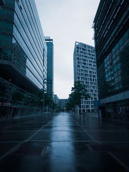 Sleek modern architecture reflecting a rainy day in Donau City, Vienna.
