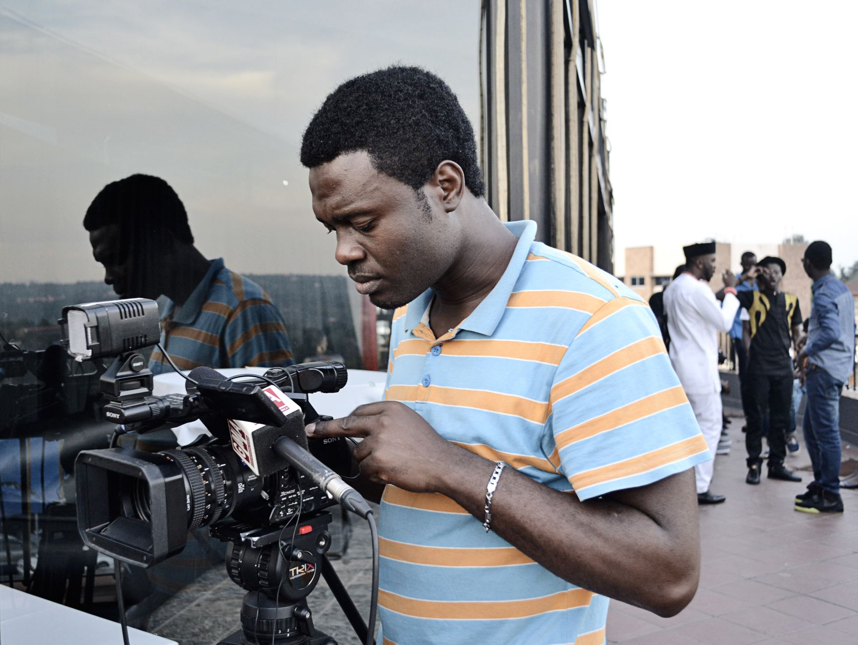 A cameraman focuses on his equipment, capturing city life in Johannesburg, South Africa.