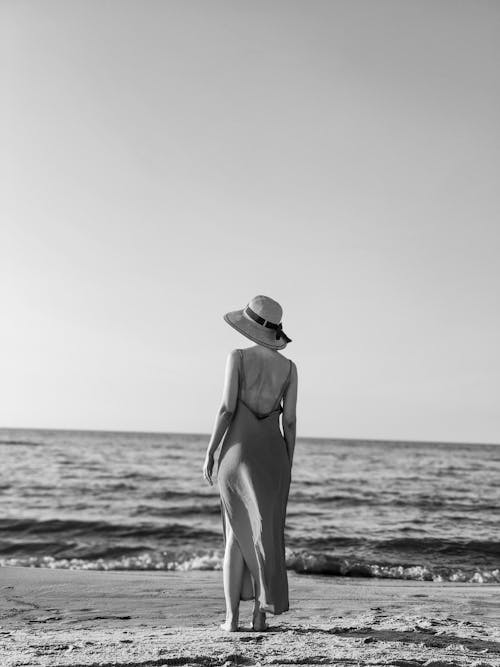 https://images.pexels.com/photos/17943173/pexels-photo-17943173/free-photo-of-woman-in-backless-slip-dress-and-straw-hat-standing-on-a-sea-beach.jpeg?auto=compress&cs=tinysrgb&dpr=1&w=500