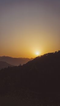 Capture of a calm and peaceful sunset over mountainous terrain, ideal for mobile wallpapers.