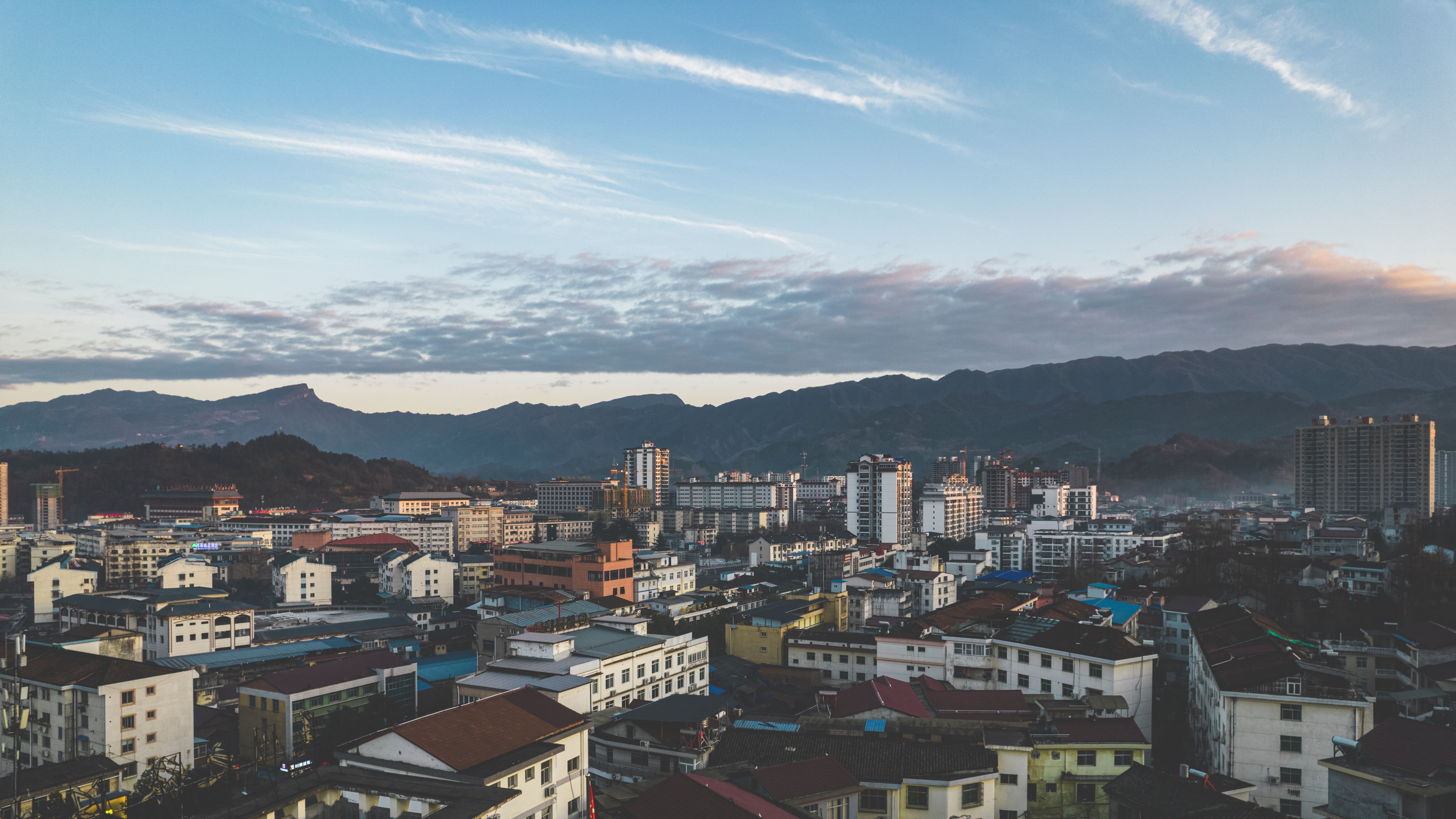 Stunning aerial view of Hanzhong cityscape with mountains in the background, capturing urban life and natural beauty.