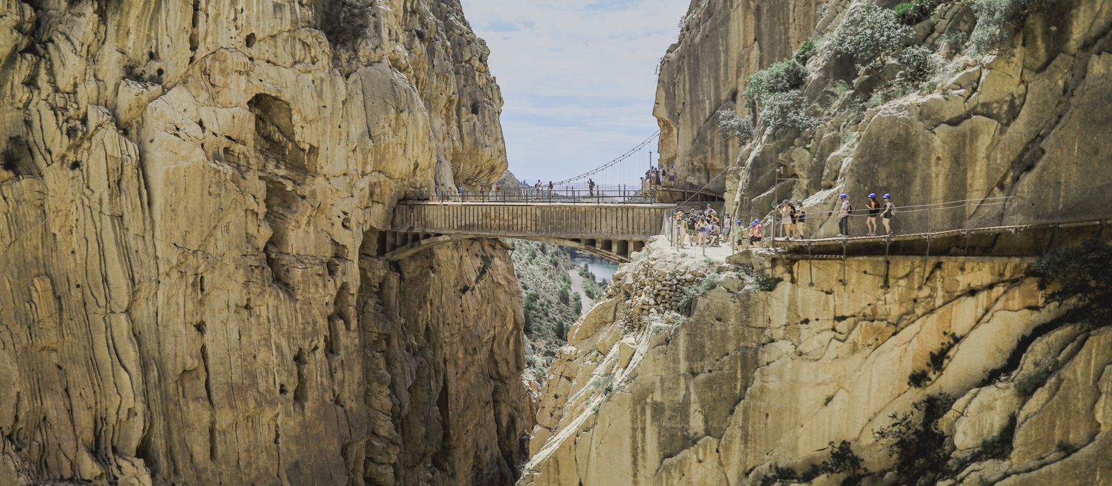 Explore the breathtaking Caminito del Rey footbridge nestled between rugged cliffs in Spain's mountains.