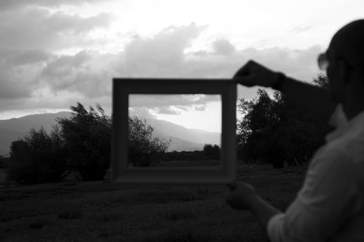 Woman Holding a Picture Frame against a Landscape