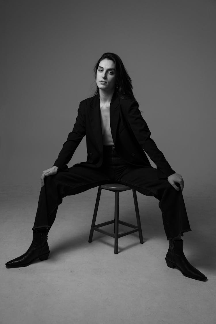 Brunette Woman Posing In Black Blazer, Jeans, And Boots