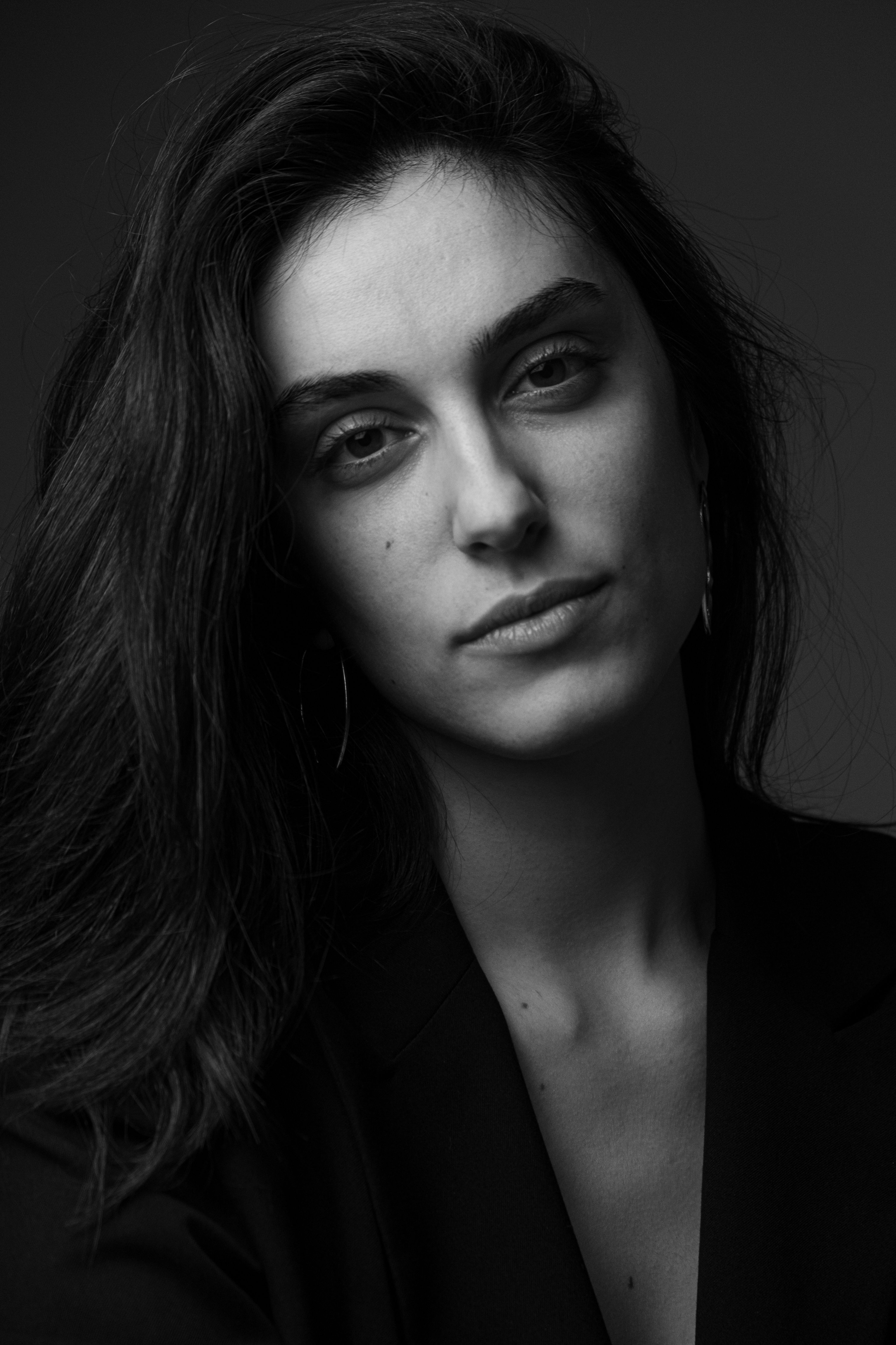 Captivating black and white portrait of a woman with long dark hair, showcasing elegance and style.