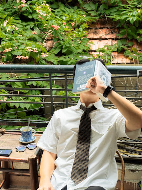 Young Man Reading a Book on the Balcony