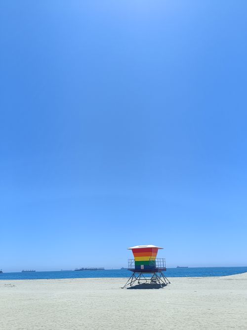 Free Colorful lifeguard tower on a sunny Long Beach, CA day overlooking the calm ocean. Stock Photo