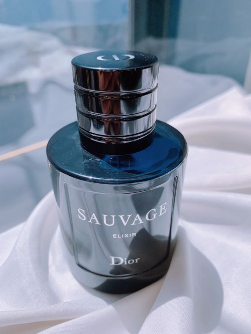 Free Sophisticated Dior Sauvage perfume bottle on white silk background. Stock Photo