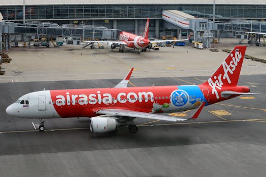 AirAsia plane parked at terminal on a busy airport runway