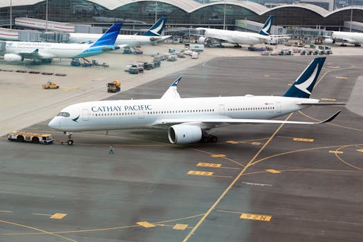A Cathay Pacific plane stationed on the airport runway ready for departure.
