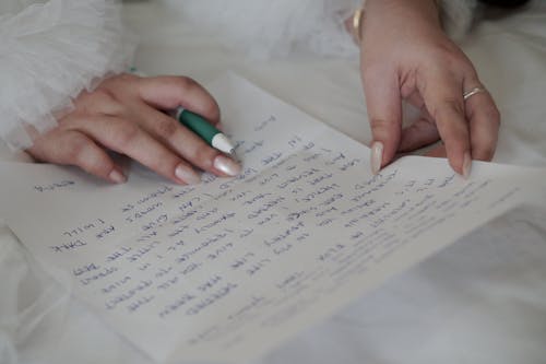 Woman in White Wedding Dress Writing a Letter with a Pen