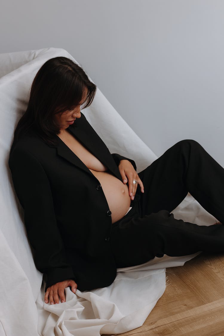 Pregnant Brunette Woman In Black Suit Touching Her Belly