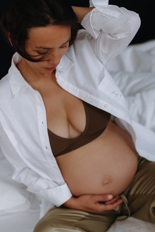 Pregnant Woman Posing in White Unbuttoned Shirt 