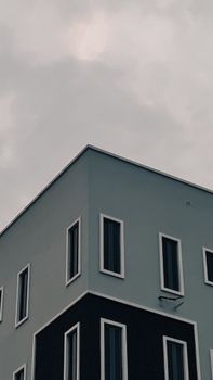 Contemporary building corner captured under a moody overcast sky with minimalist design.
