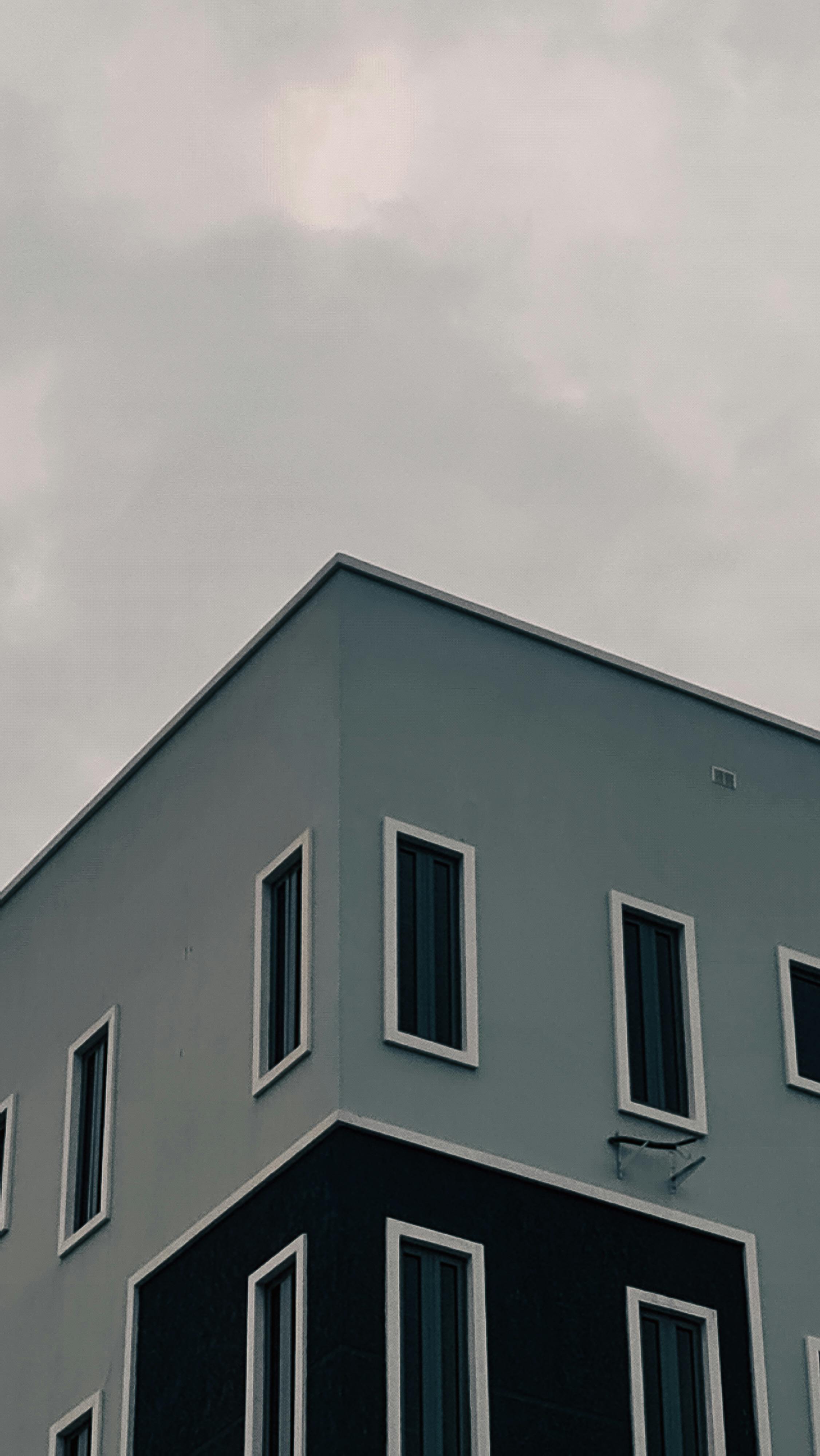 Free Contemporary building corner captured under a moody overcast sky with minimalist design. Stock Photo