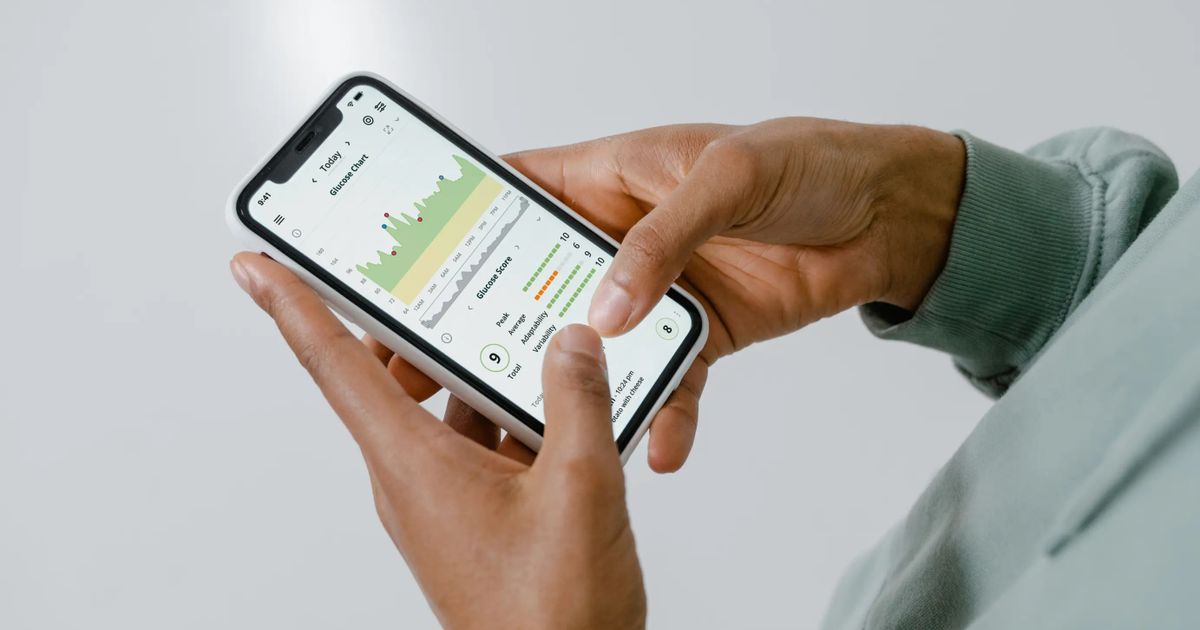 Hände halten ein Smartphone mit einer App zur Erfassung von Zeiten und Kennzahlen