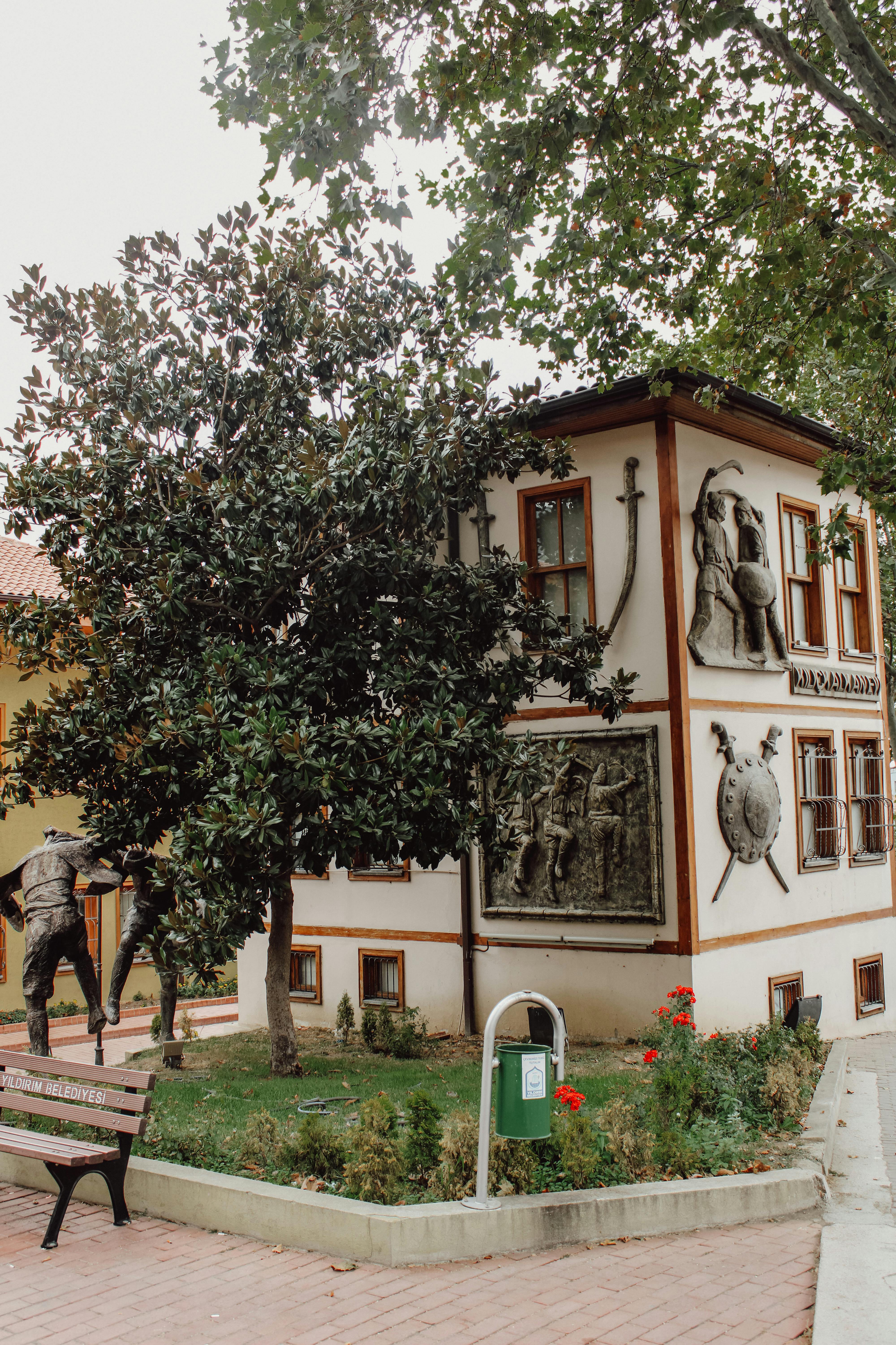 Exterior view of Kılıç Kalkan Evi museum in Bursa, featuring historical sculptures and architecture.